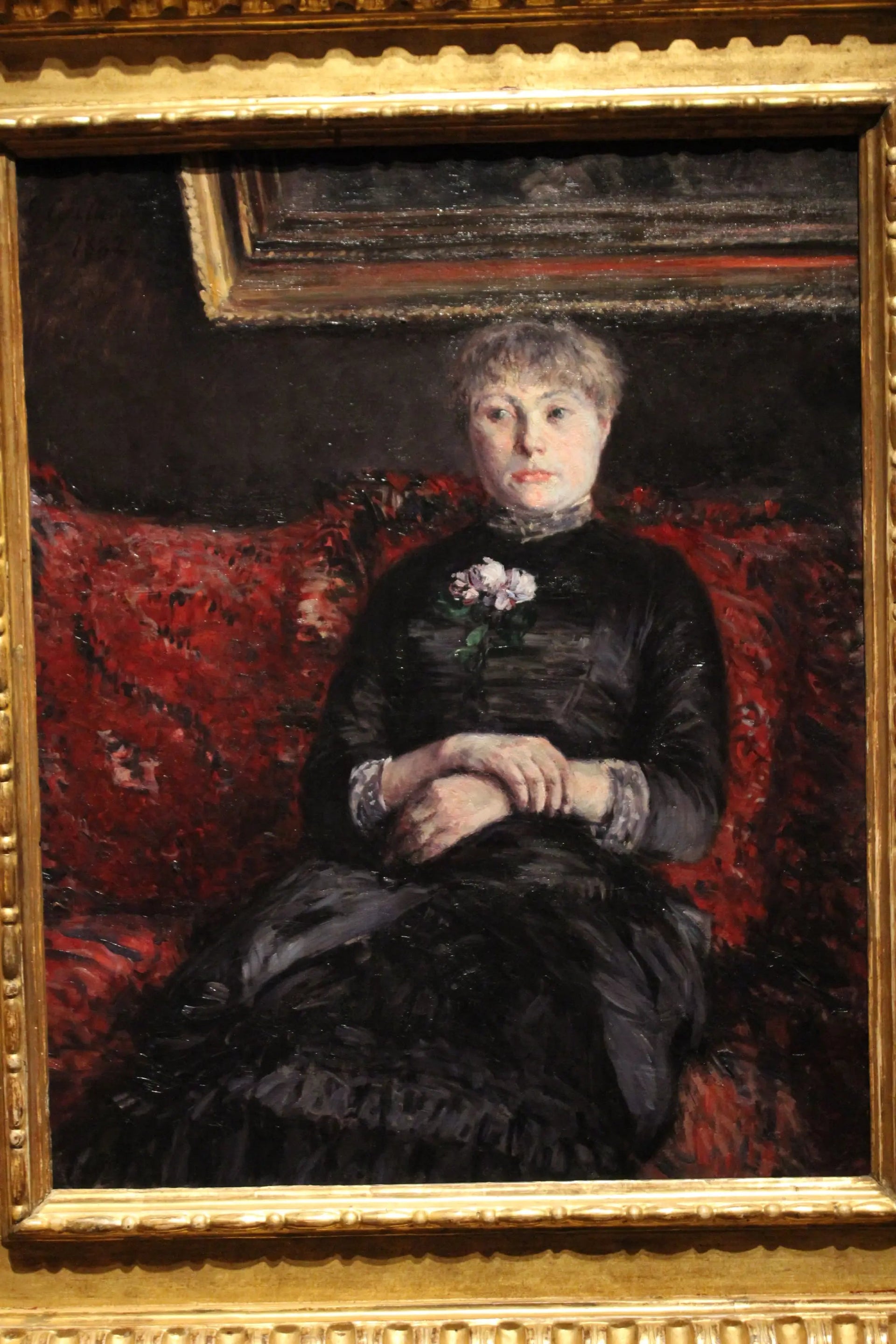 Femme assise sur un canapé à fleurs rouges - Gustave Caillebotte image 1 reproduction artisanale de tableau